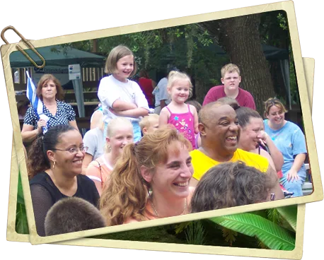Parents and children laughing together at an outdoor Jungle Jimmy show