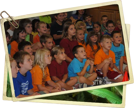 A large group of schoolchildren in bright t-shirts watching the show
